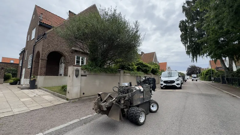 Stubbfräs på hjul parkerad på en villagata